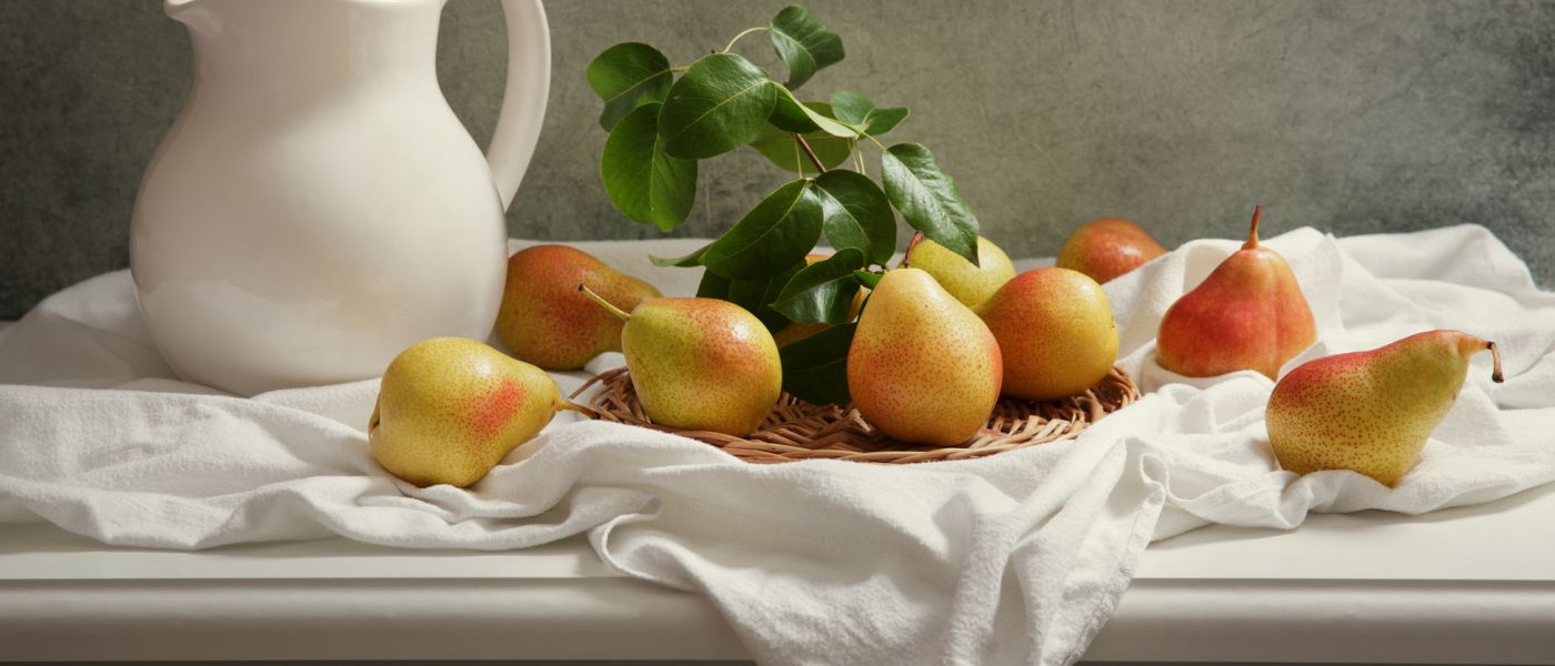 still life with fresh pears with leaves on wooden table